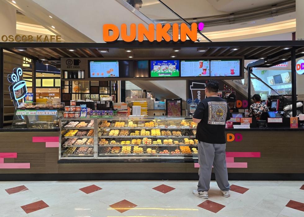 Customer waiting in line at a Dunkin' Donuts stand.