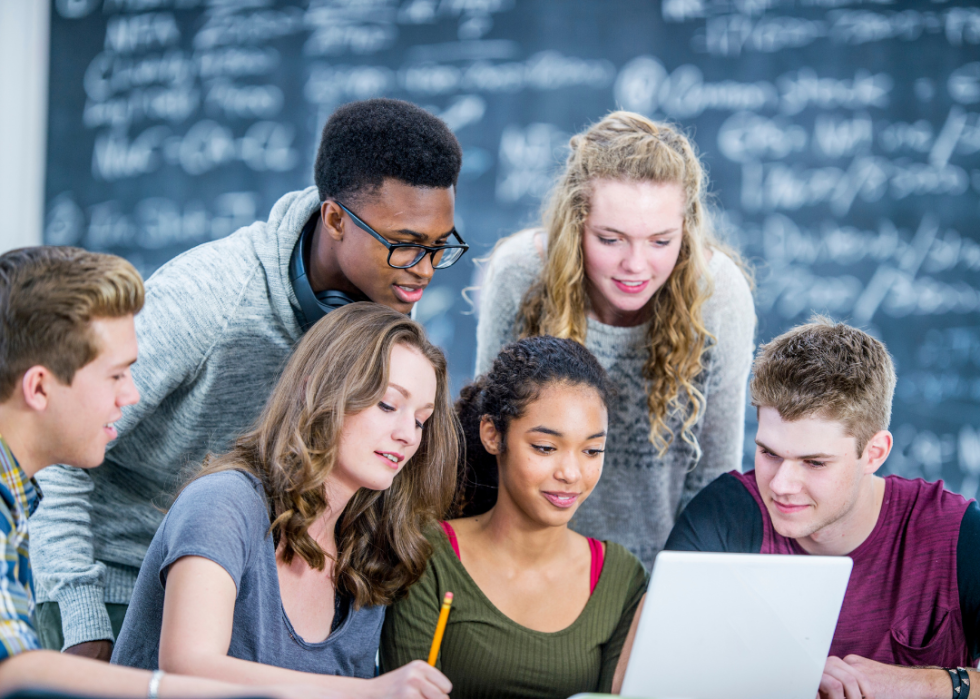 A group of students in a classroom looking at the computer screen.