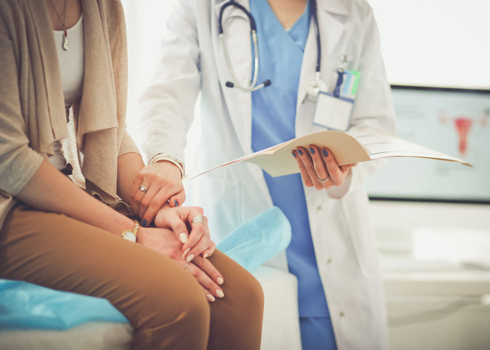 A doctor placed her hand on the arm of a patient sitting on the exam table.