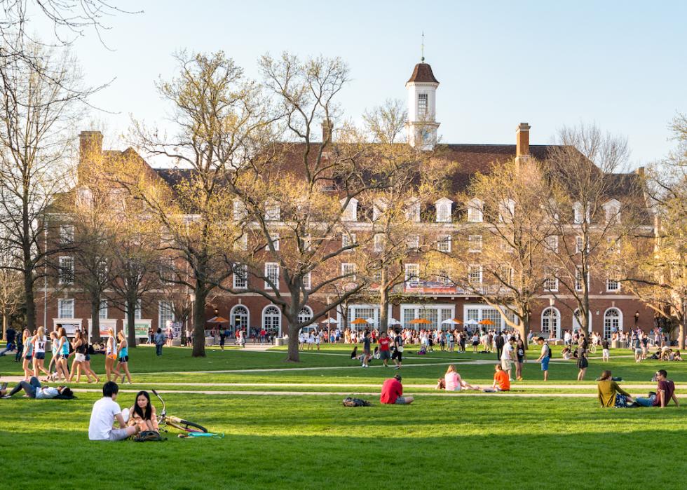 Students walk and sit outside on the quad at the University of Illinois college campus in Urbana Champaign.