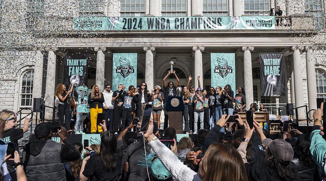 Members of the New York Liberty team celebrate their championship at a ticker tape parade.