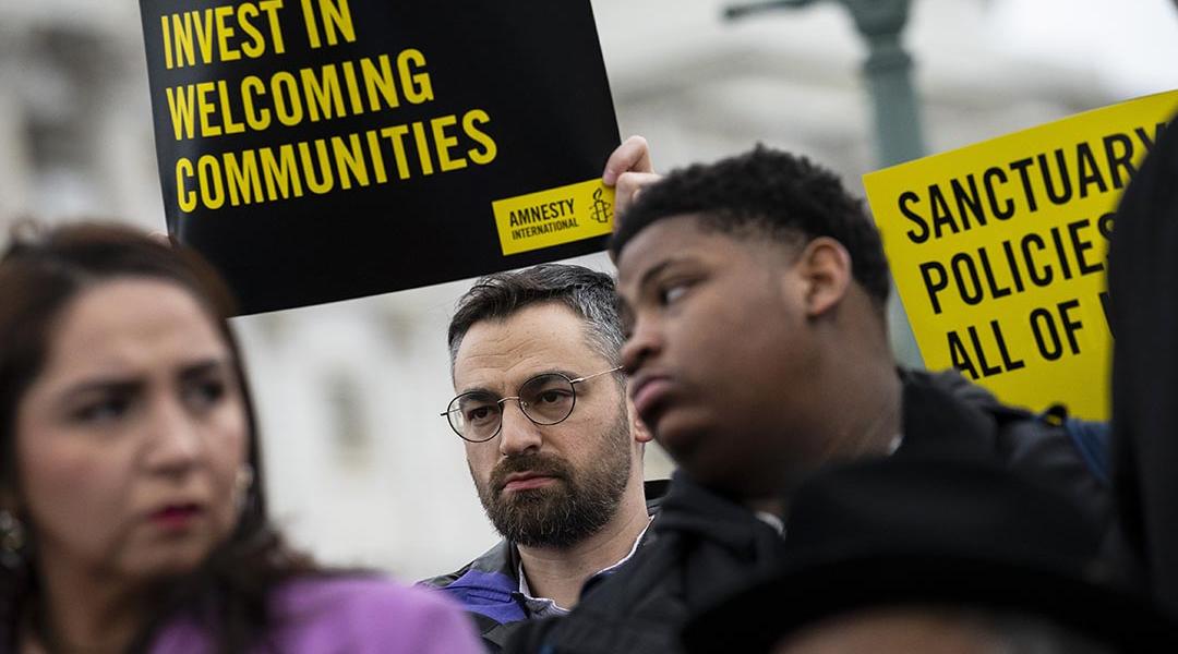 People hold signs in support of sanctuary city mayors outside the U.S. capitol, on Wednesday, March 5, 2025 in Washington, D.C.