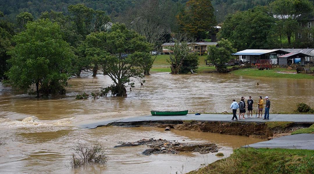 Residents that canoed the flooded South Fork New River talk at a washed out road on September 27, 2024 in Boone, North Carolina