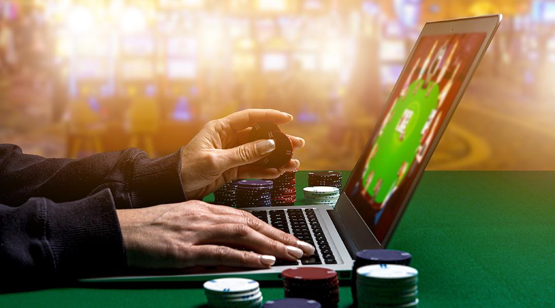 Person using laptop playing online casino.
