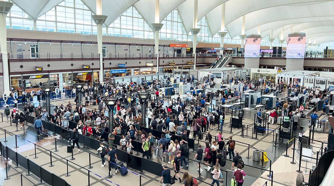 A high-angle view of a crowded TSA security checkpoint at Denver International Airport (DIA).