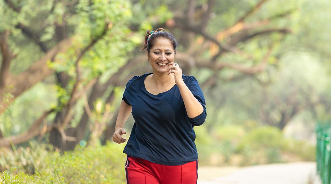 A middle-aged woman jogging at the park.