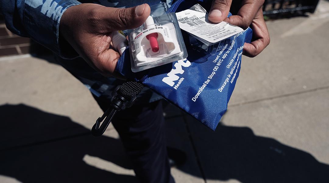 A Services for the UnderServed (S:US) worker holds a naloxone overdose kit.