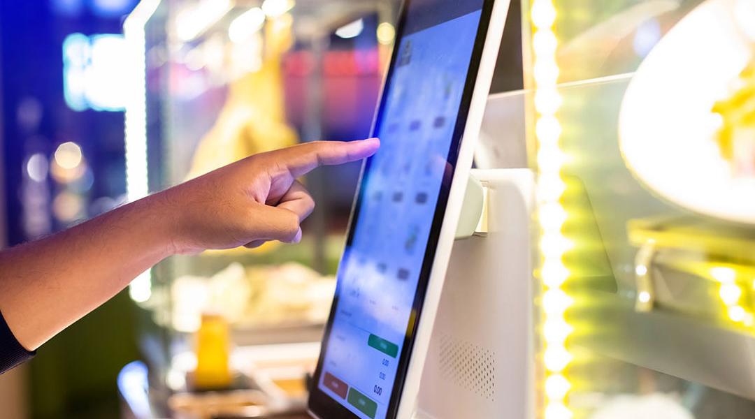 Customer using a digital menu to choose their food and pay electronically.