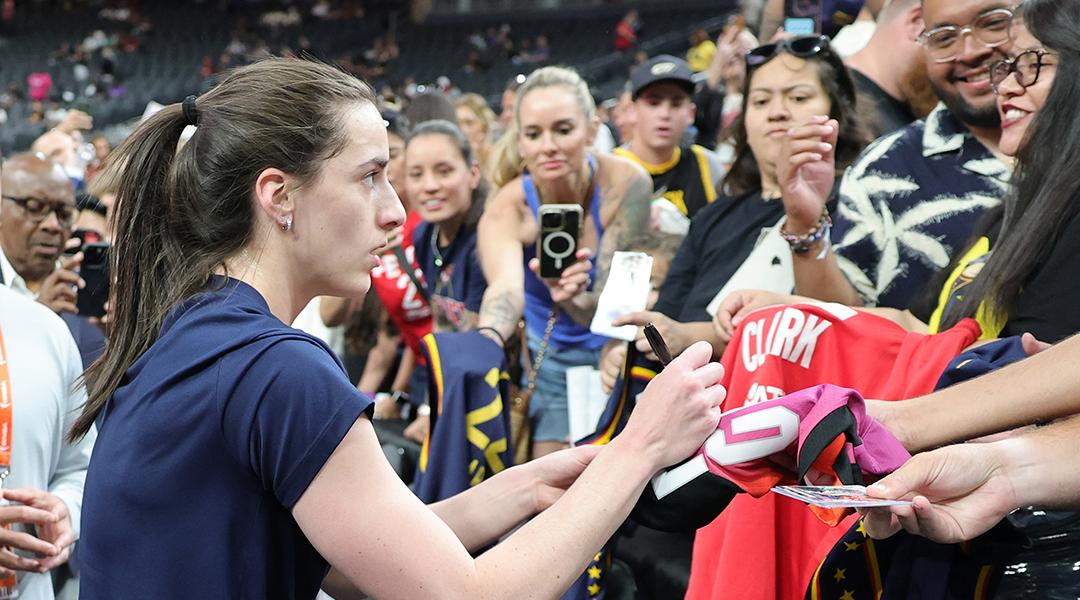 Caitlin Clark #22 of the Indiana Fever signs autographs for fans after warming up before a game against the Las Vegas Aces at T-Mobile Arena on June 22, 2025 in Las Vegas, Nevada.