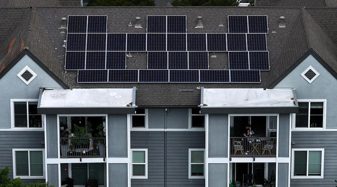 Aerial view of solar panels are on the roof of an apartment complex in California.