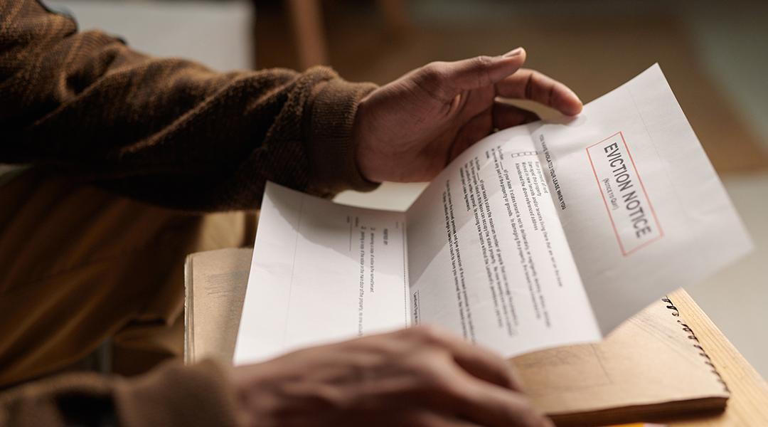 Close-up of a person reading an eviction notice letter.