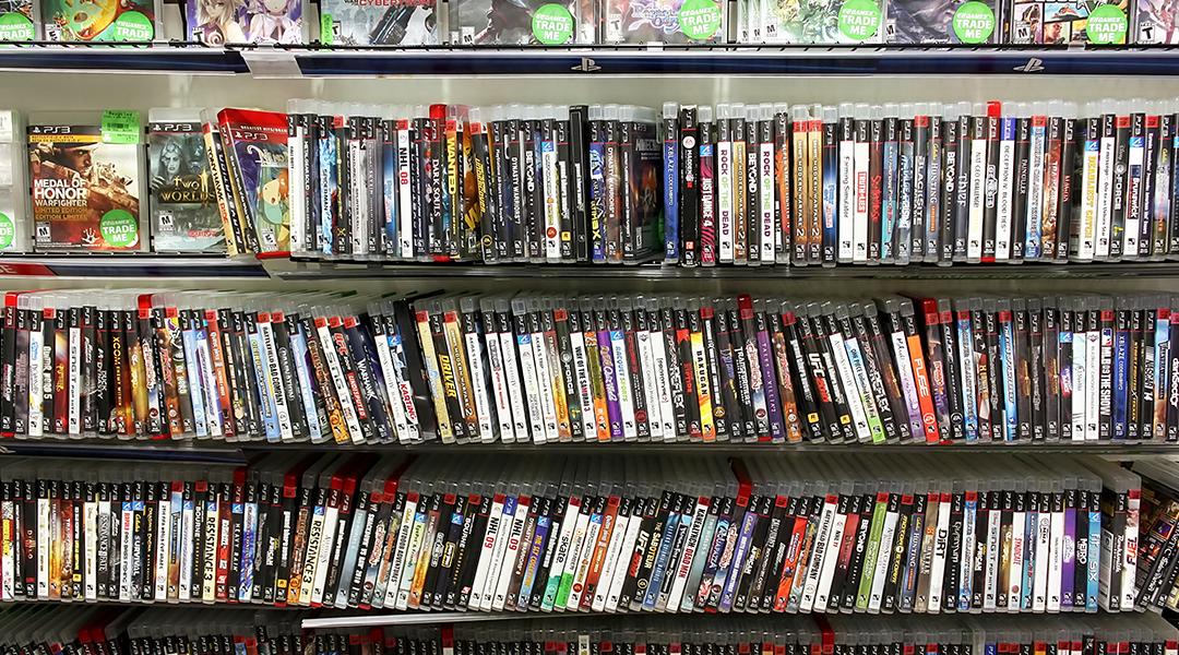 PlayStation game discs on display at a game store.