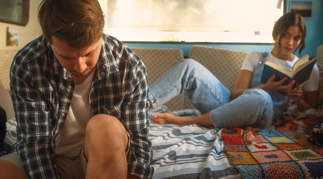 A young couple living inside a renovated, stylish old bus.