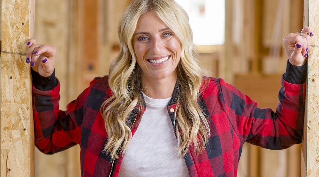 Jasmine Roth poses for a portrait inside a home renovation, wearing red and black buffalo check plaid. 