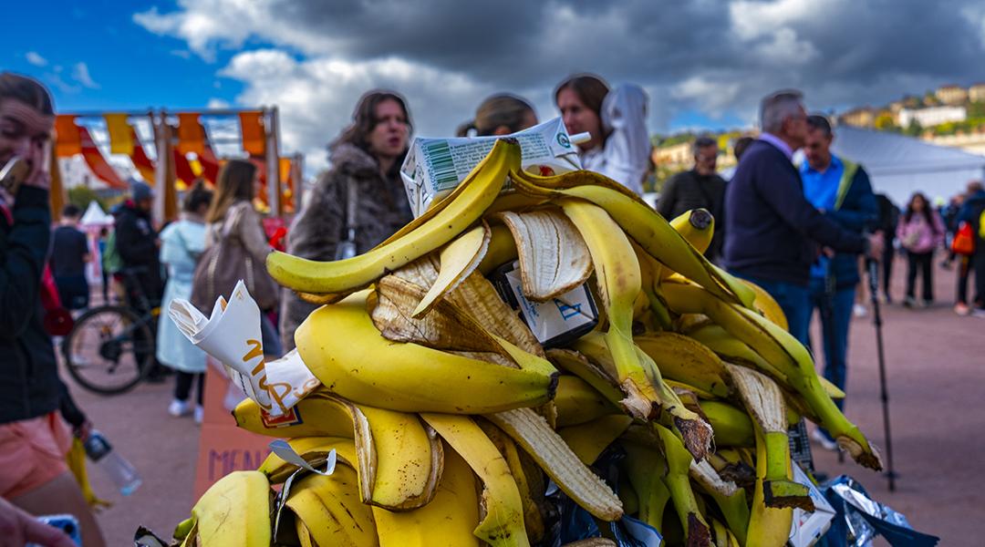 A pile of banana peels in the trash during a marathon in a city.