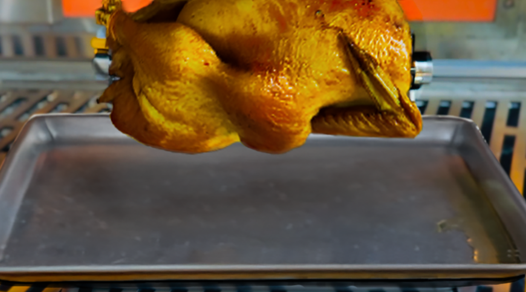A chicken being roasted in a rotisserie oven.
