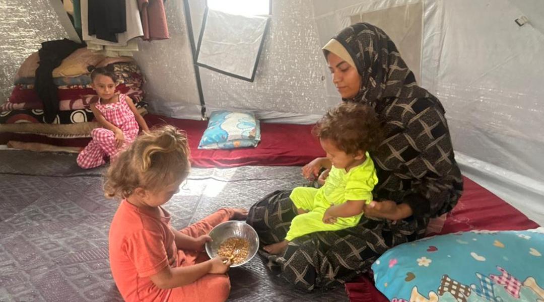 Recently widowed single mother, Noura Abu Dan, with her small children in a refugee camp on Sheikh Mohammed Ahmed.