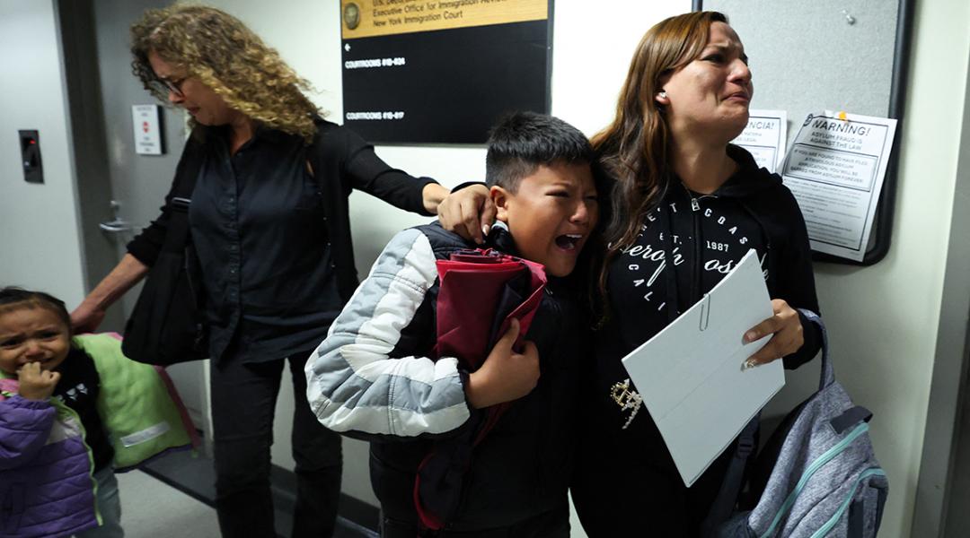 A wife and her children crying as her husband is detained by federal agents outside a New York Federal Plaza Immigration Court room in New York City.