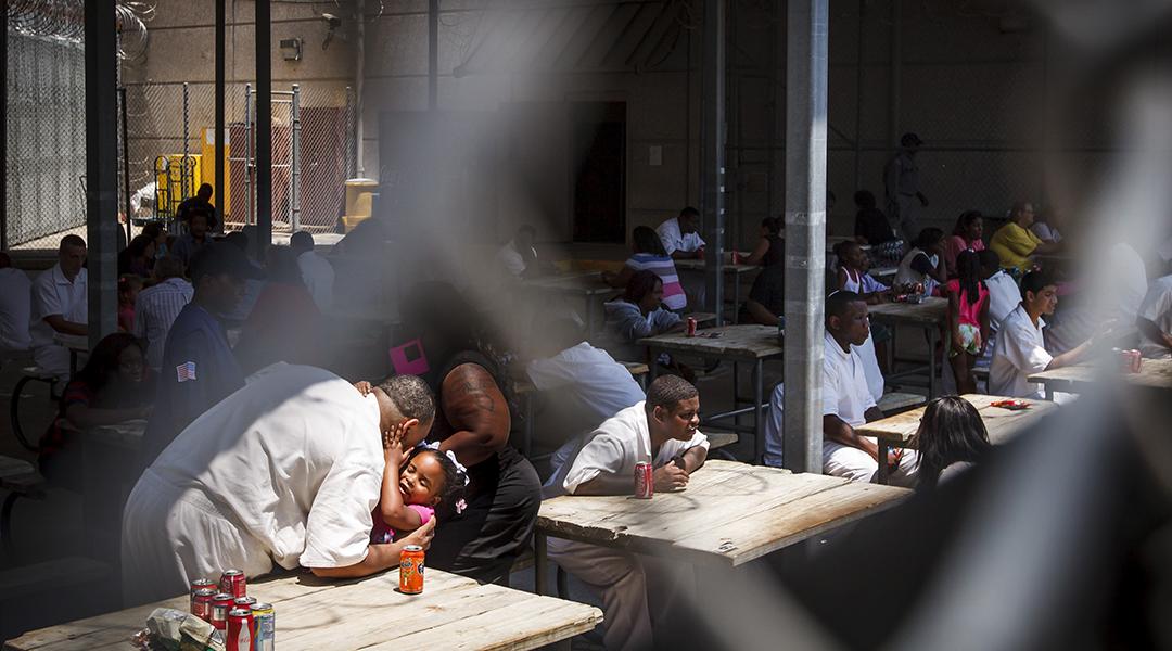 An inmate gives his daughter a hug and kiss during Father's Day at Joe Kegans State Jail's visiting hall.