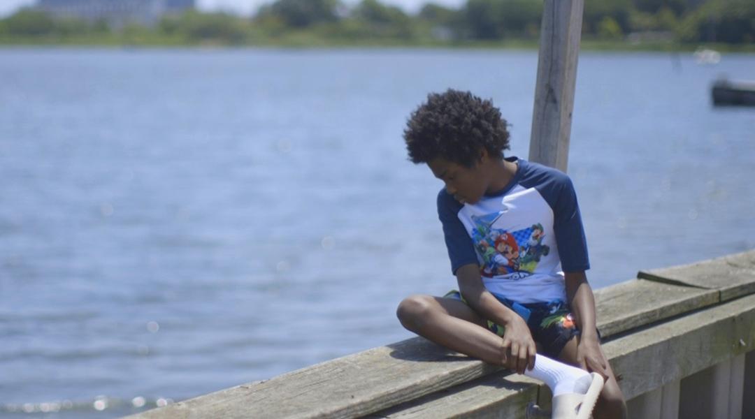A boy looking out over Jamaica Bay in the Edgemere neighborhood of New York City.
