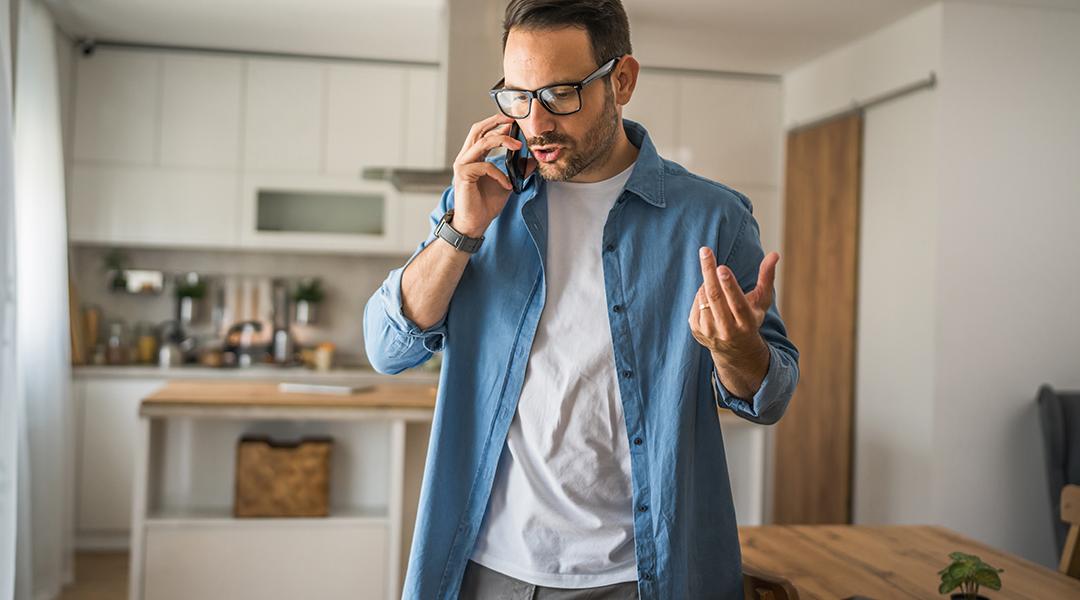 A man at home talking on the phone.