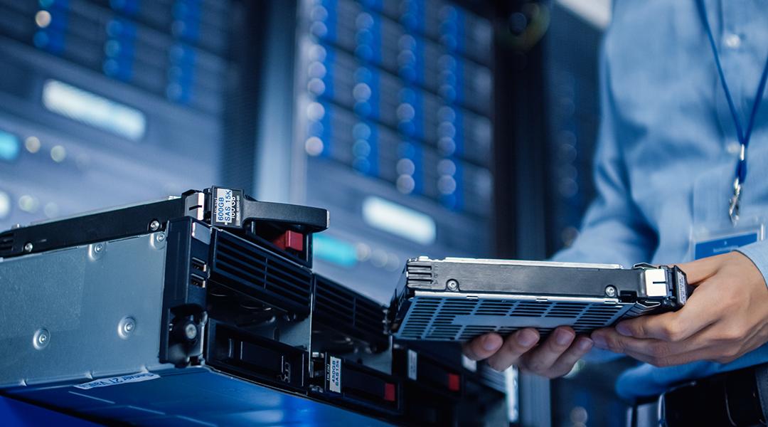 An IT engineer preparing to install new hardware into a server pack.