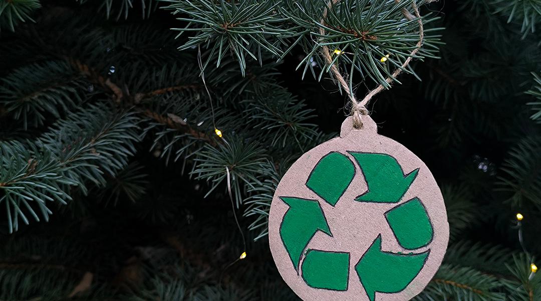 A recycling symbol ornament on a Christmas tree.
