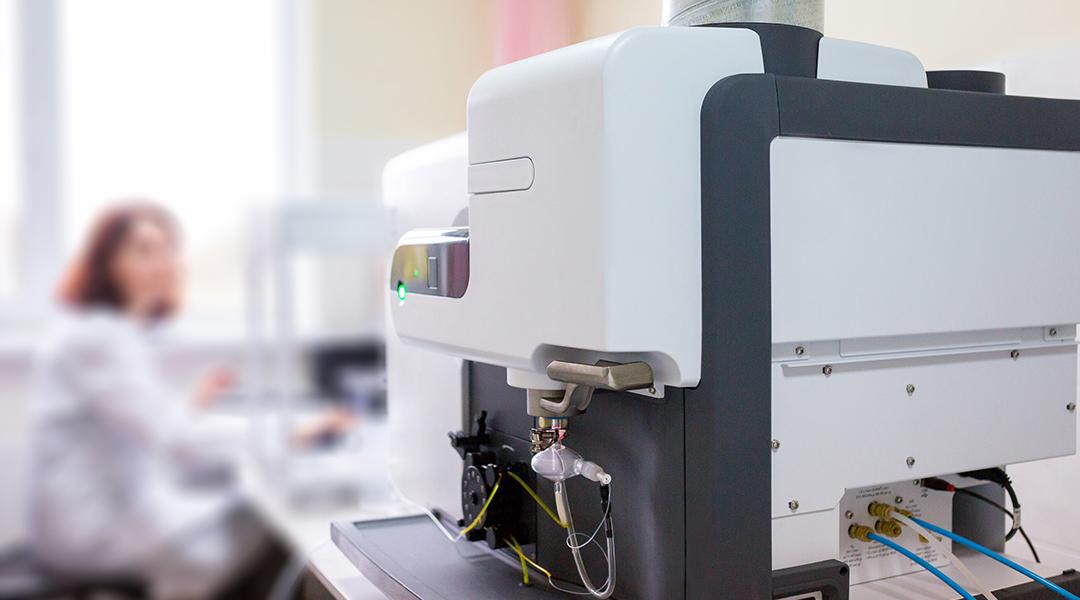 A focus on a microwave plasma atomic emission spectrometer (MPAES) a scientist is working with in a laboratory.