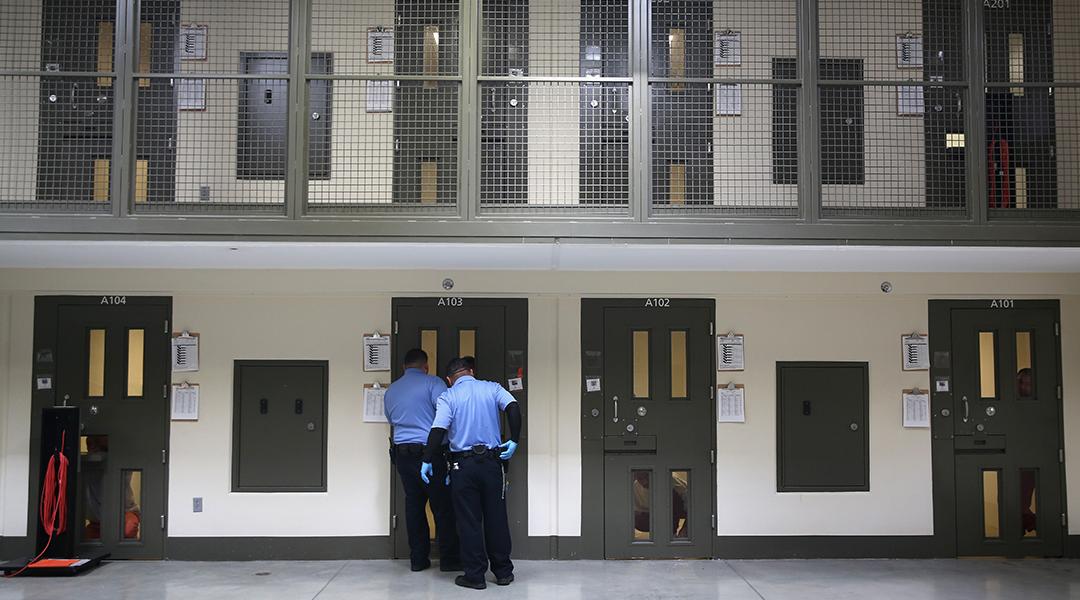Guards prepare to escort an immigrant detainee from his 'segregation cell' back into the general population at the Adelanto Detention Facility on November 15, 2013 in Adelanto, California.